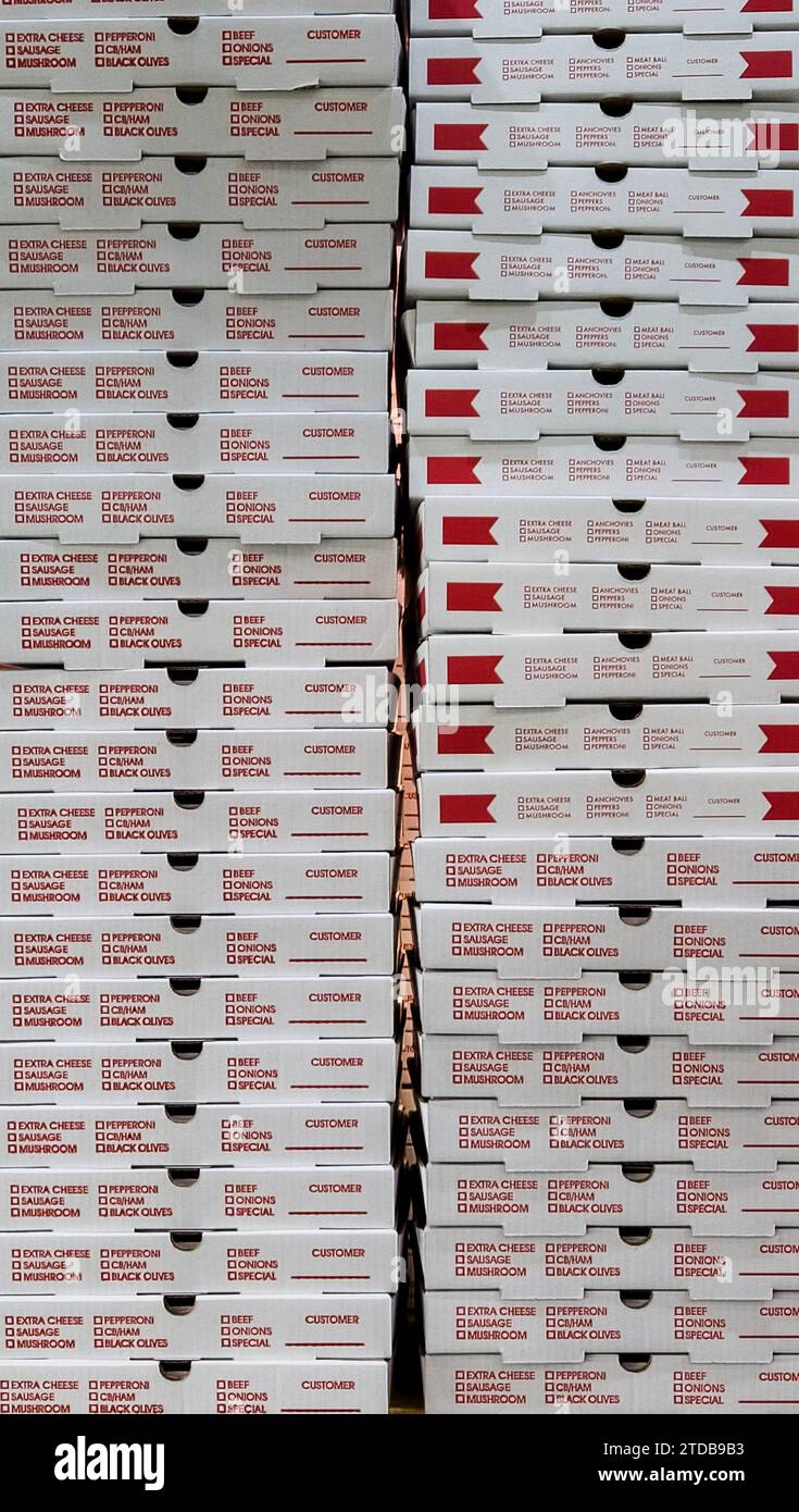 Stack of red and white pizza boxes at a restaurant Stock Photo