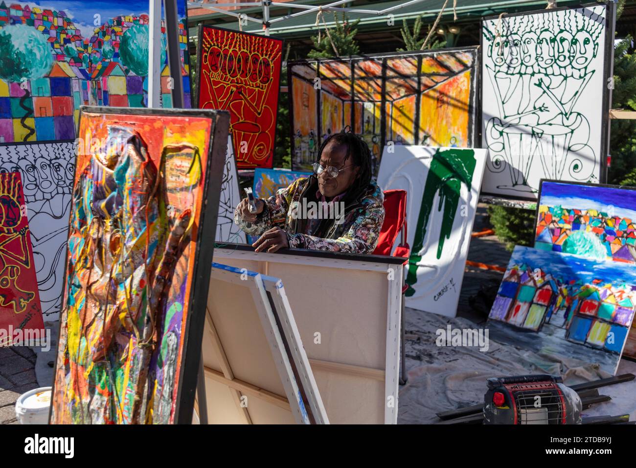 Washington, DC - Cherif Mamadou frames his artwork in his booth at Eastern Market on Capitol Hill. He was born in Côte d'Ivoire (Ivory Coast) and rais Stock Photo