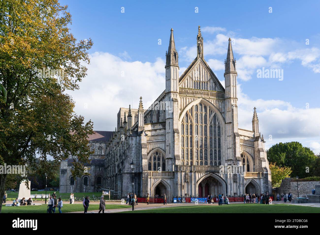 The western facade (or west front) of the gothic Winchester Cathedral in late afternoon autumn sunshine with a poppy appeal banner and visitors. UK Stock Photo