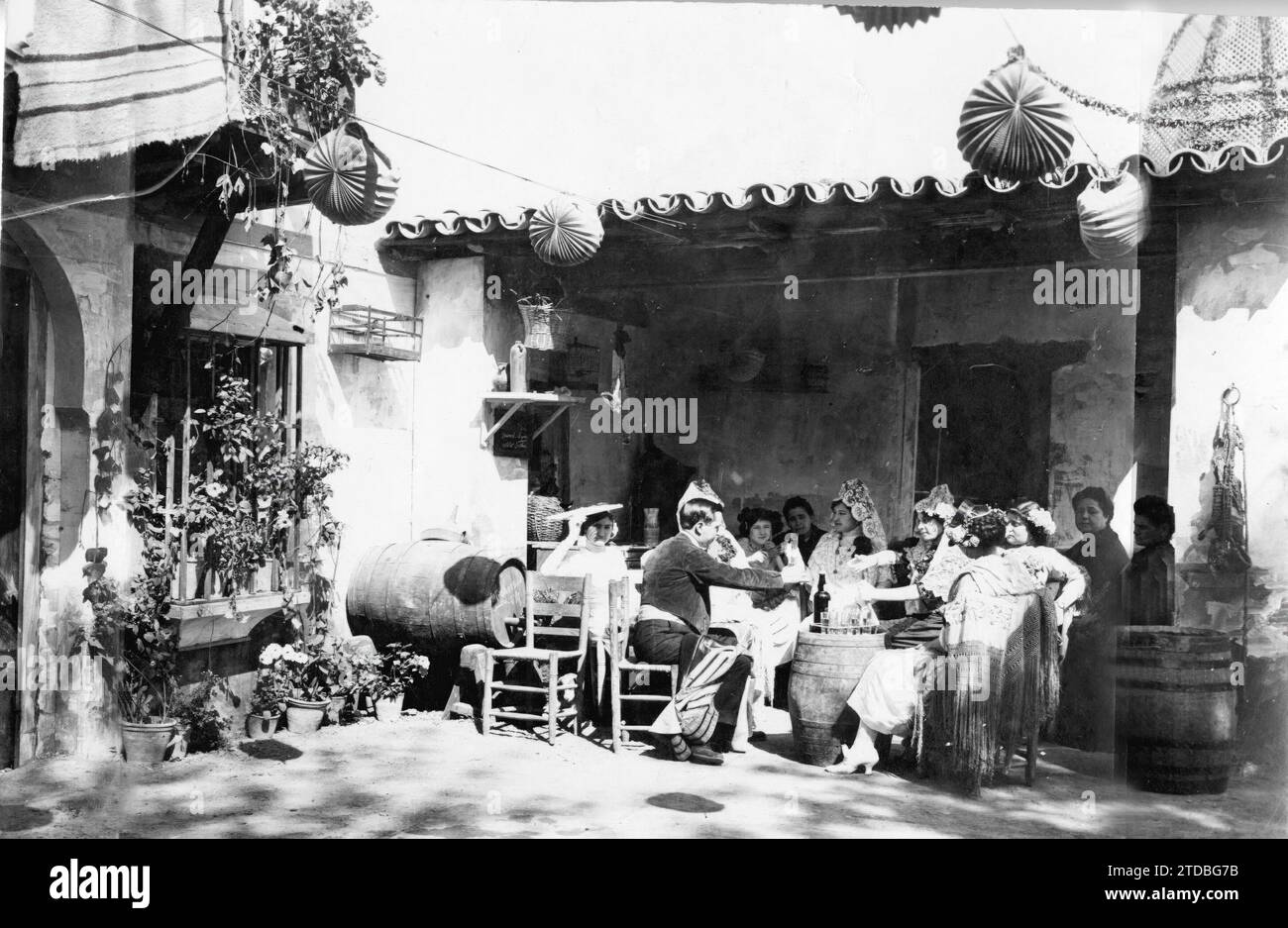 Seville. April 1929. Flamenco party at the Ateneo booth. Bocoyes of generous wine, manila shawls over the back of the cattail chairs and white mantillas. The meeting alternates with fine wine served in catavinos as is done today. Four Venetian lanterns add decoration to the booth. Credit: Album / Archivo ABC Stock Photo