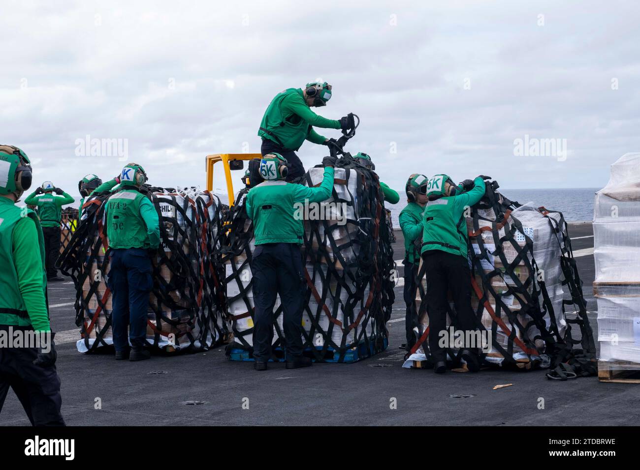 231209NTY7041583 PHILIPPINE SEA (Dec. 9, 2023) Sailors remove nets from cargo on the flight