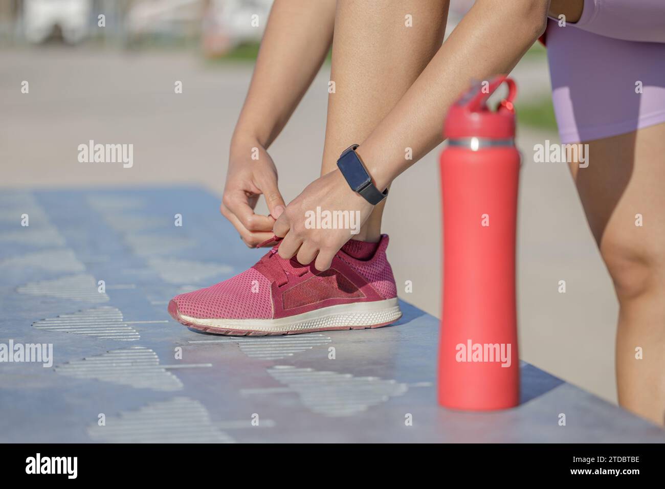 Detail of a girl's feet tying the laces of her sneaker. Stock Photo