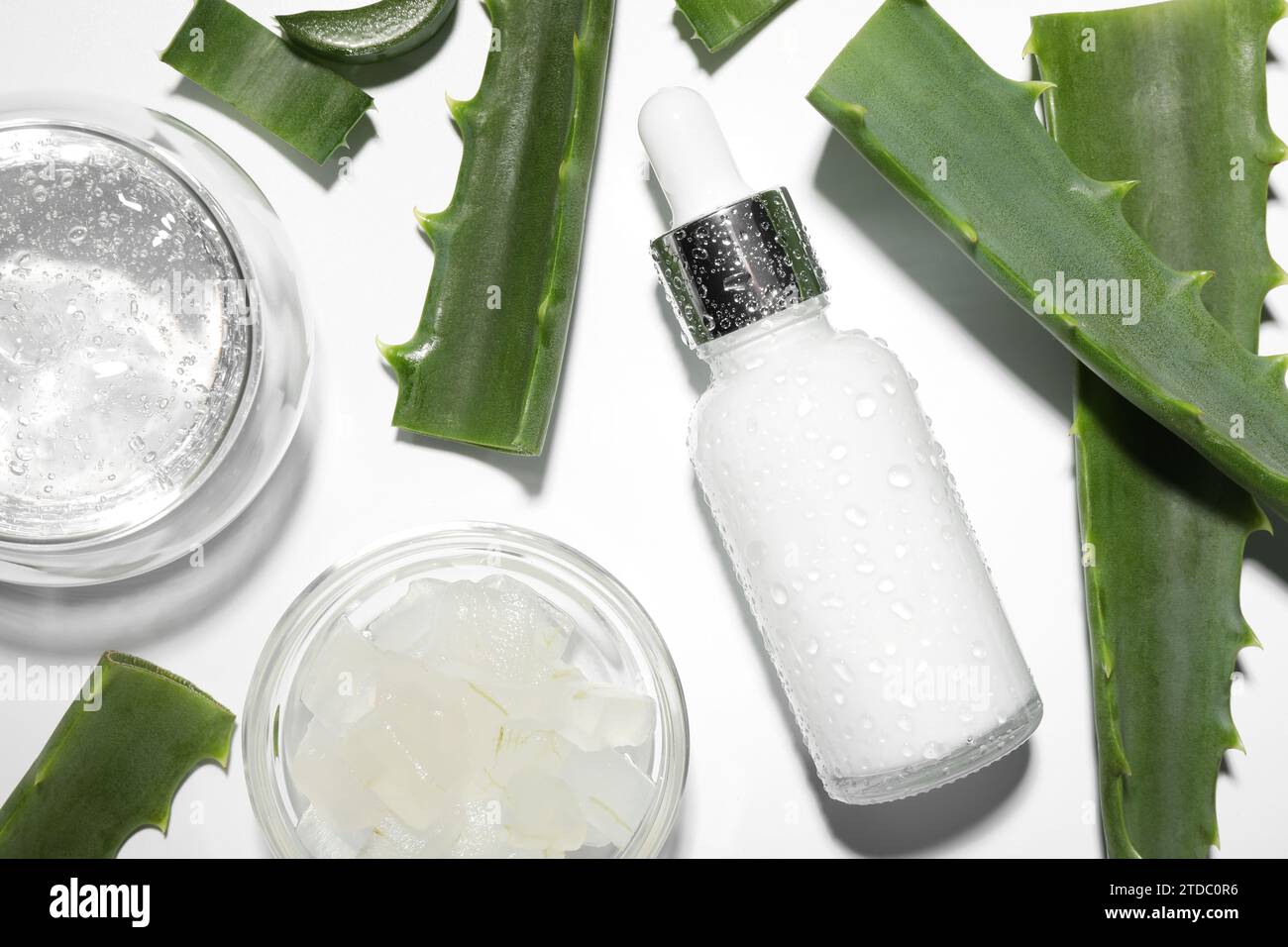 Flat lay composition with cosmetic products and cut aloe vera on white ...