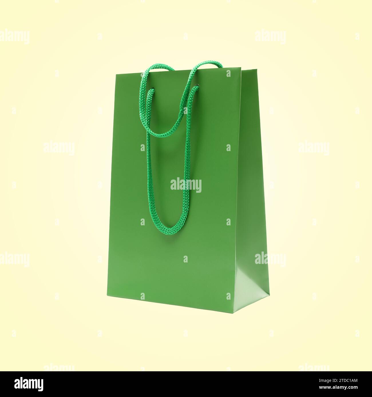 Green shopping bag in air on beige background Stock Photo - Alamy