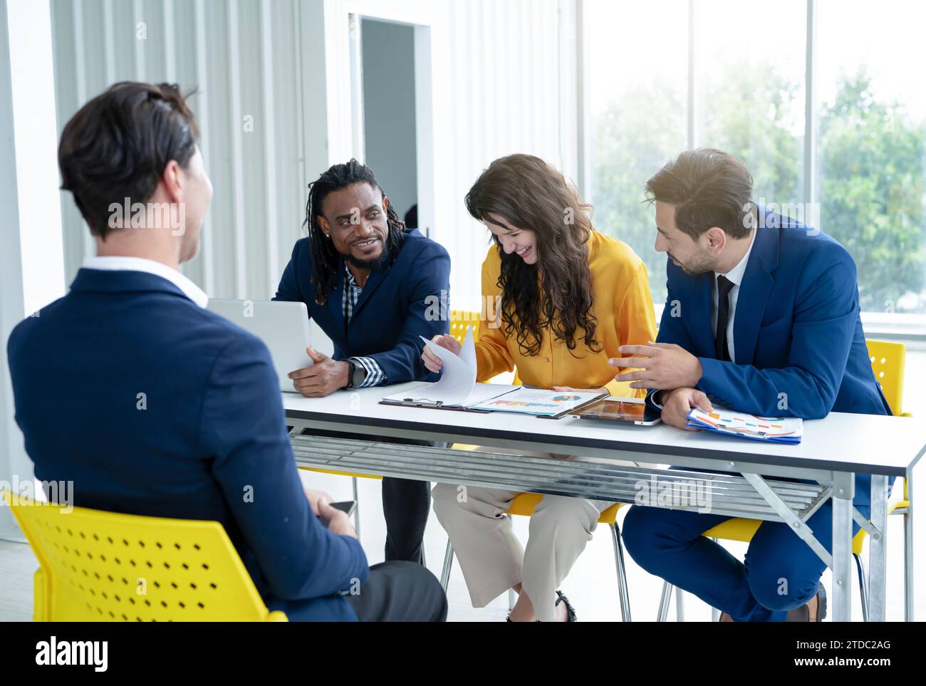 Job interview concept. Diverse hr team doing job interview with a man in business office. Human resources team interviewing a potential job candidate. Stock Photo