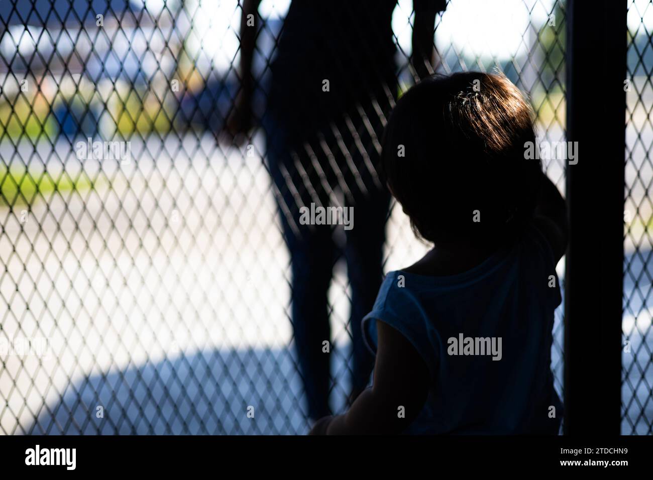 Little Boy opening the door to the robber. Child Is Opening The Door To Stranger. Little boy alone at home. Stock Photo