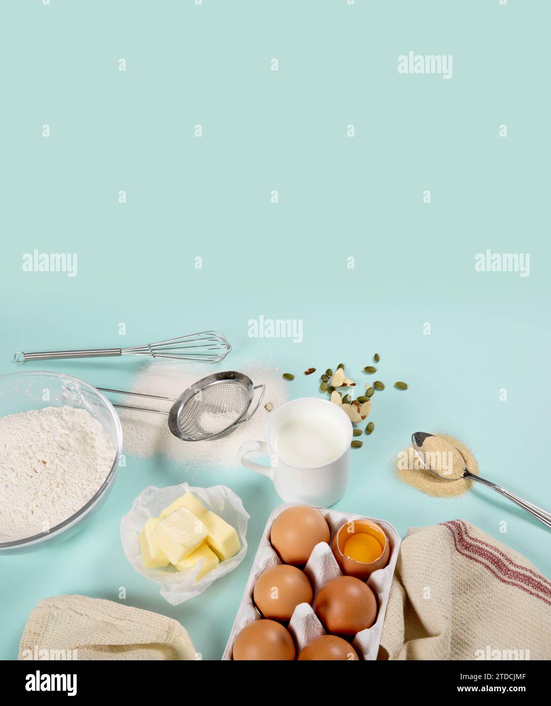 Composition of ingredients for baking on colored paper (eggs, flour, butter, nuts, milk and tools) Stock Photo