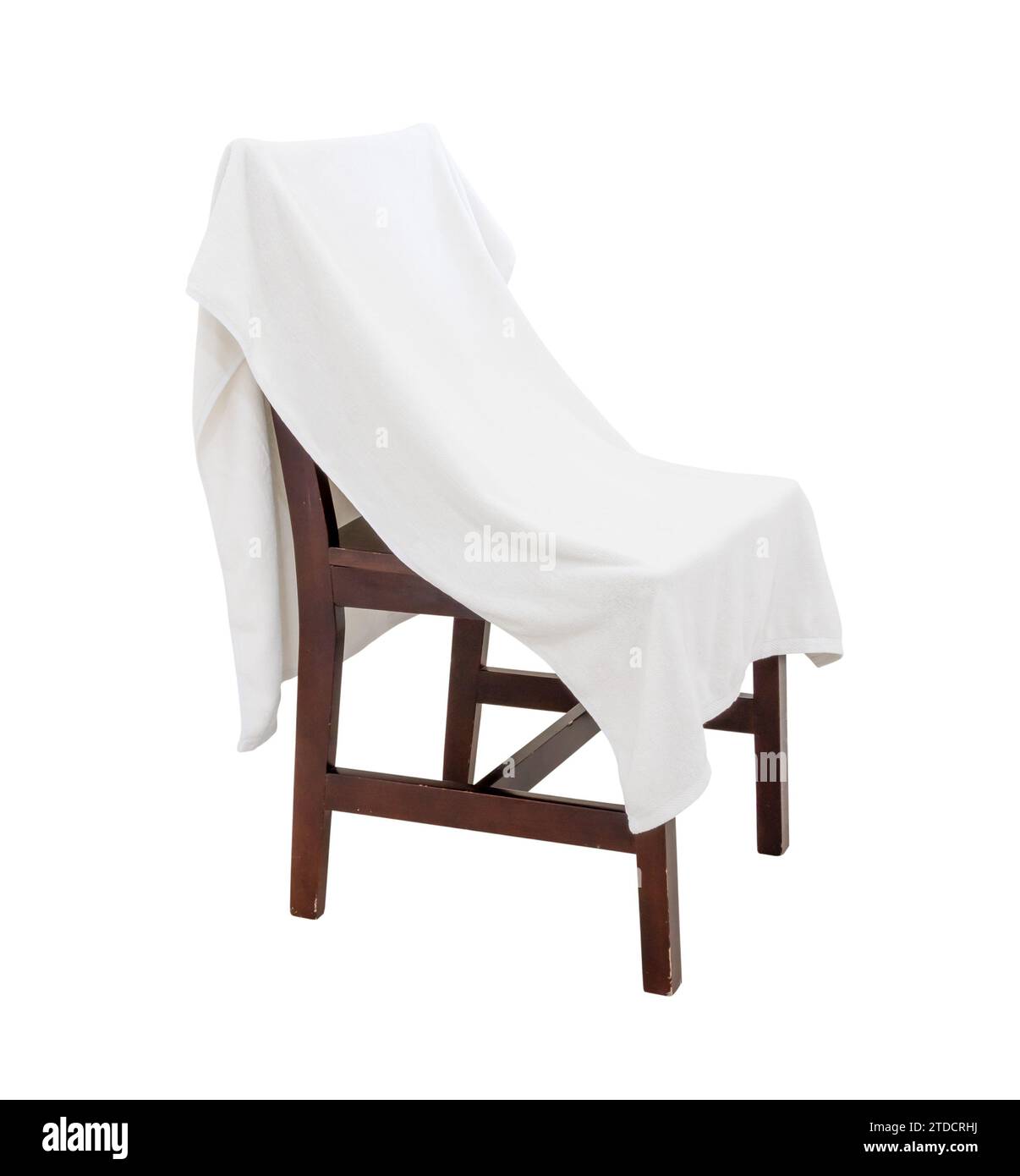 Used white towel laying on wooden chair is isolated on white background with clipping path. Stock Photo
