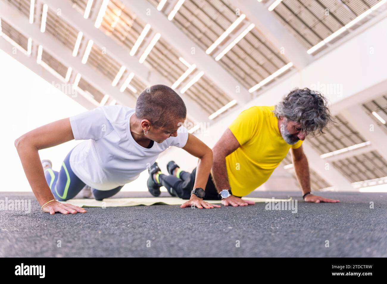 senior man doing push ups with personal trainer Stock Photo