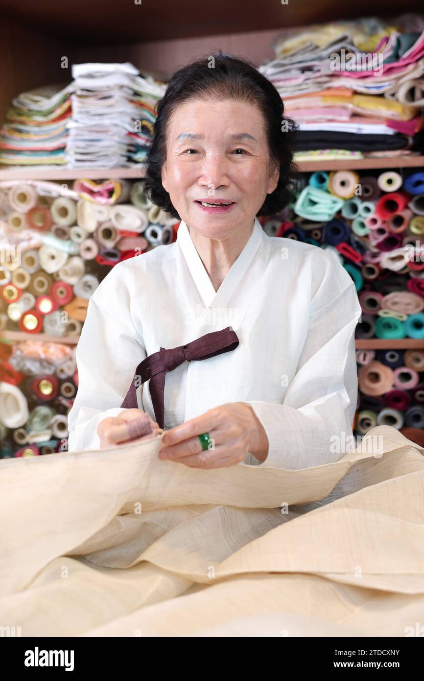A master of traditional Korean clothing, a Hanbok expert, is sewing for