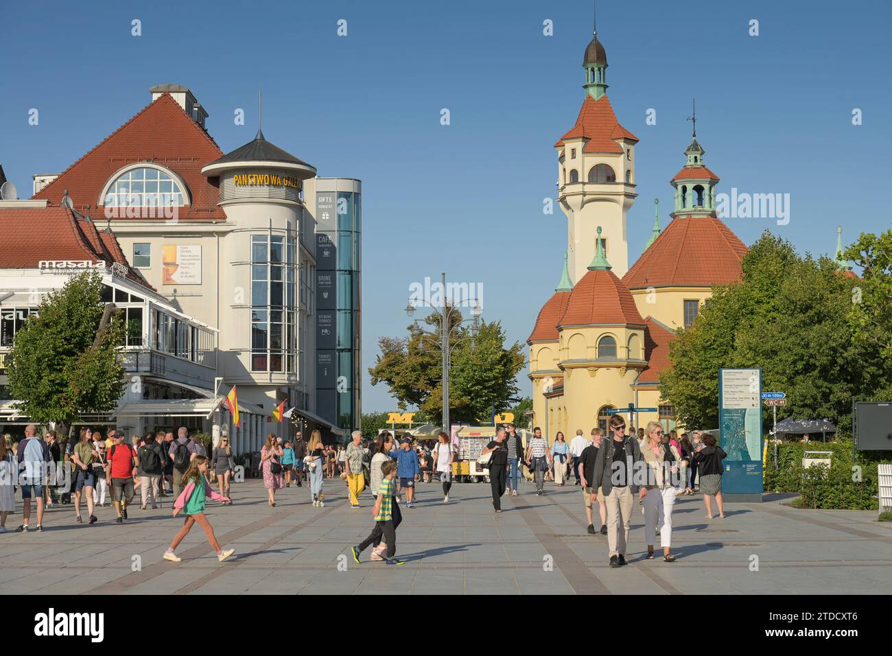 Urlauber auf dem Platz Plac Przyjaciol Sopotu, hinten rechts Leuchtturm - Latarnia Morska w Sopocie mit Therme - Zaklad Balneologiczny, Zoppot, Woiwod Stock Photo