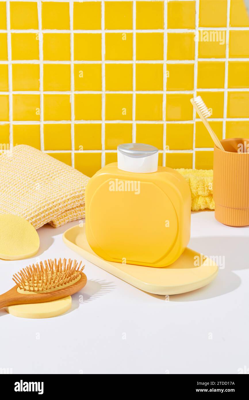 A label-free yellow shower gel bottle stands on a white table against a ...