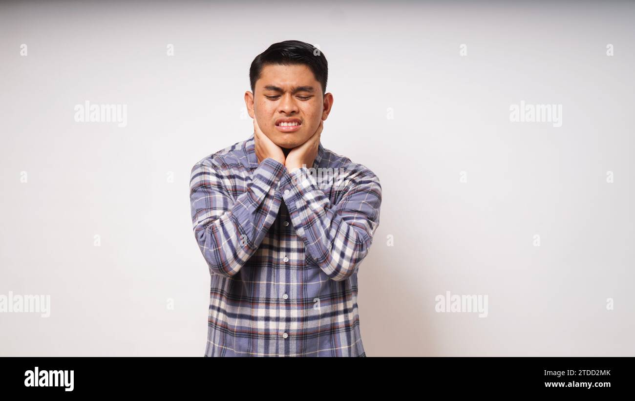 Young Asian man touching his throat showing in pain expression on white ...