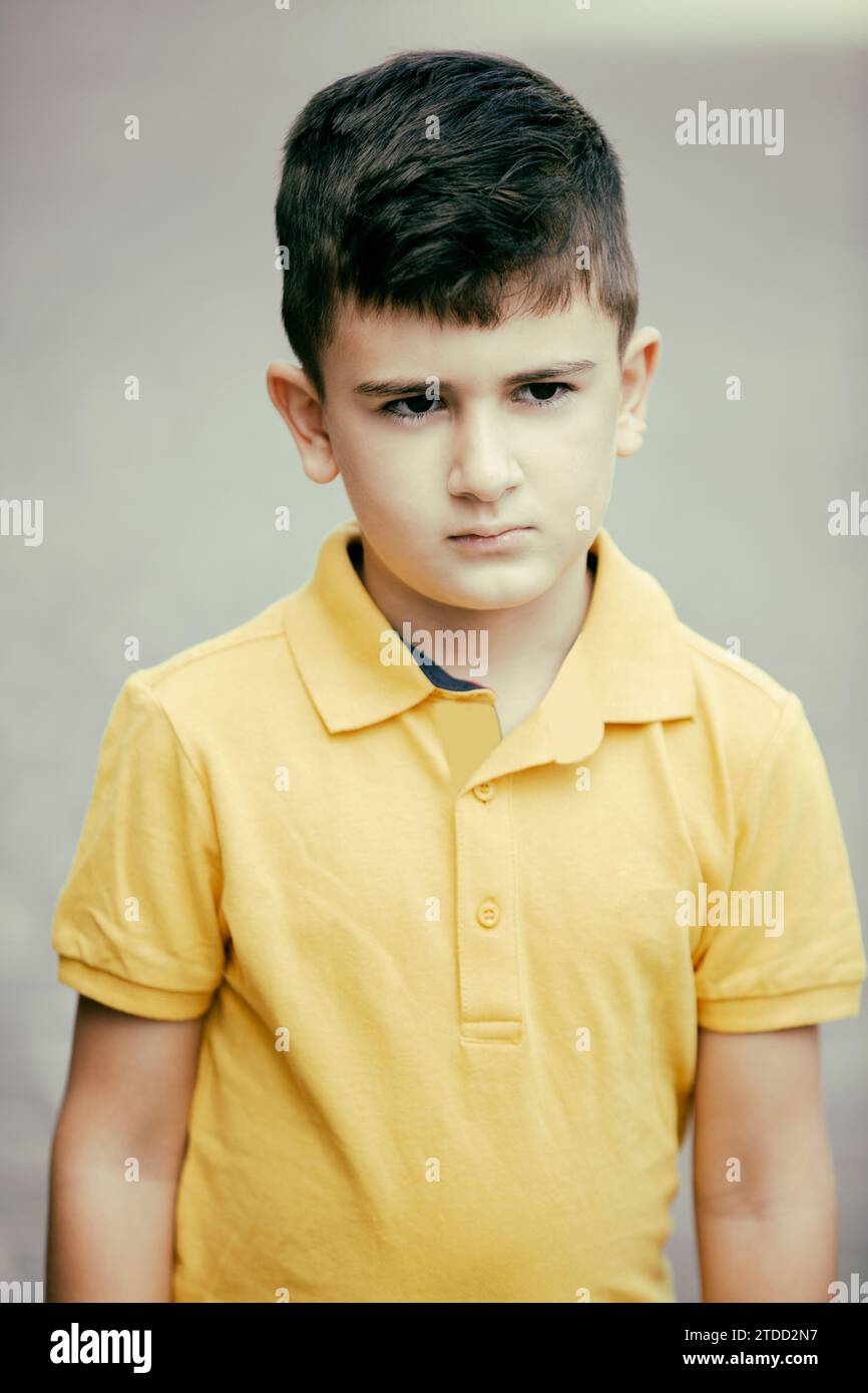 8 years old boy standing outdoors looking away Stock Photo