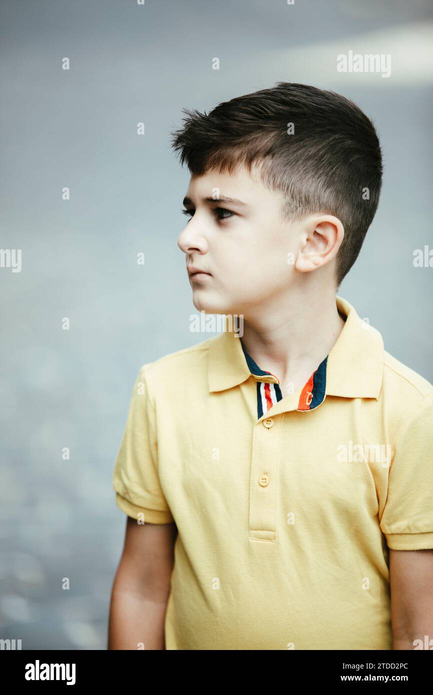 8 years old boy standing outdoors looking away Stock Photo