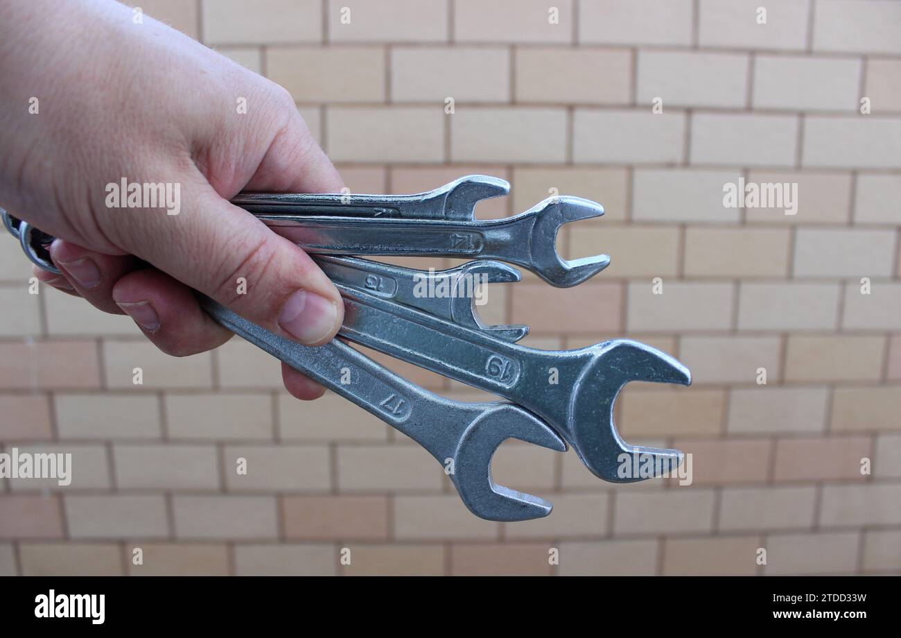 Variety Size Steel Hex Spanners In A Man Hand On A Brick Wall Background Stock Photo