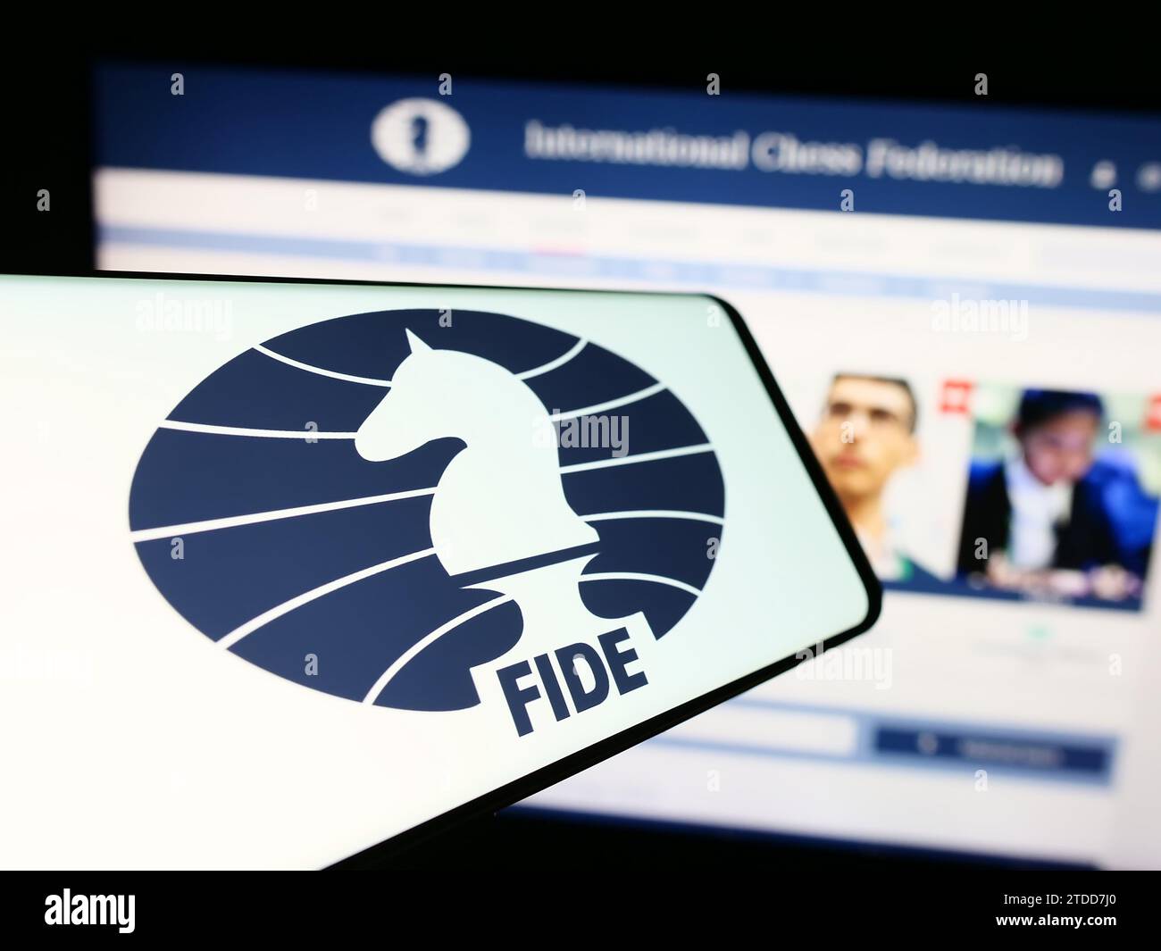 Cellphone with logo of organisation International Chess Federation (FIDE) in front of website. Focus on center of phone display. Stock Photo