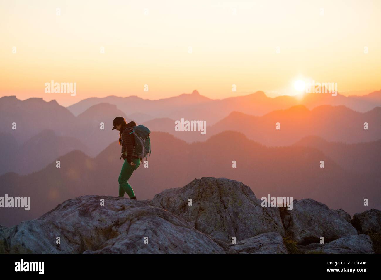 Hiker walking mountain ridge at sunset Stock Photo