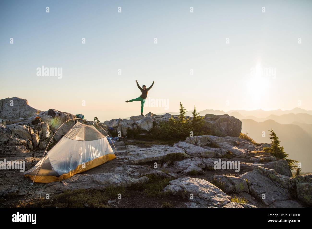 confident fit woman feeling good camping on mountain summit. Stock Photo