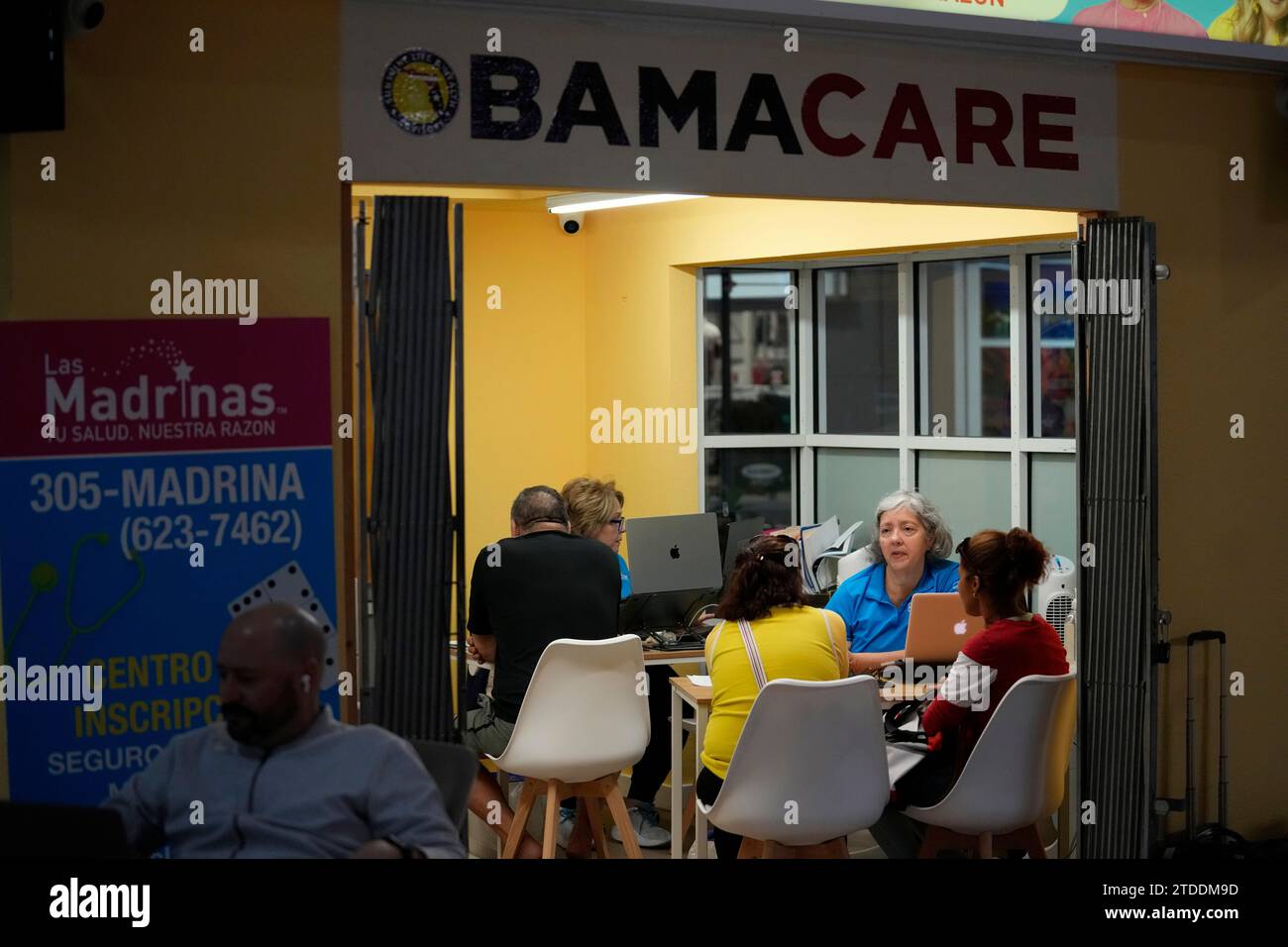 Insurance agent Maria Collado, center right, works with clients at a ...