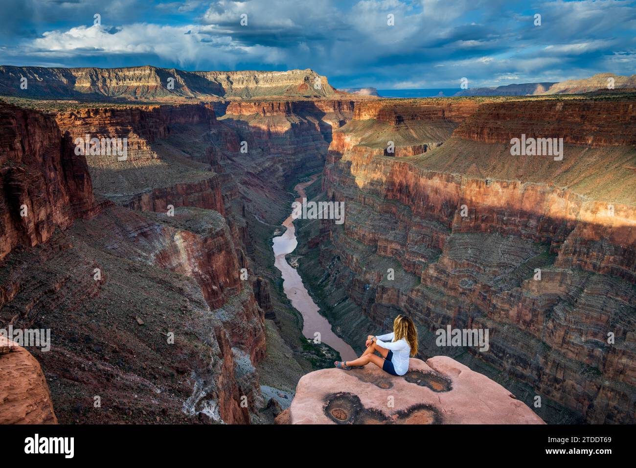 Woman Sitting and Looking out over the Grand Canyon Stock Photo