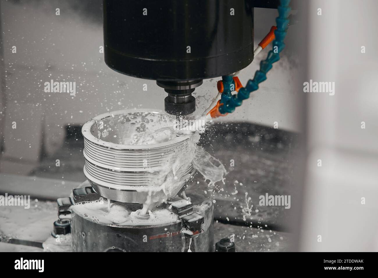 CNC milling machine cutting aluminium automotive part with a coolant