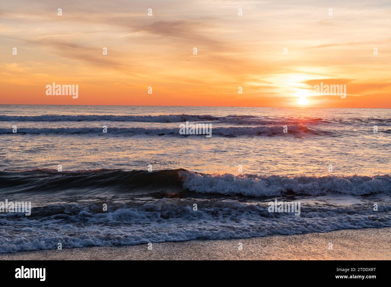 sunrise over the waves of the Atlantic Ocean from the beach Stock Photo