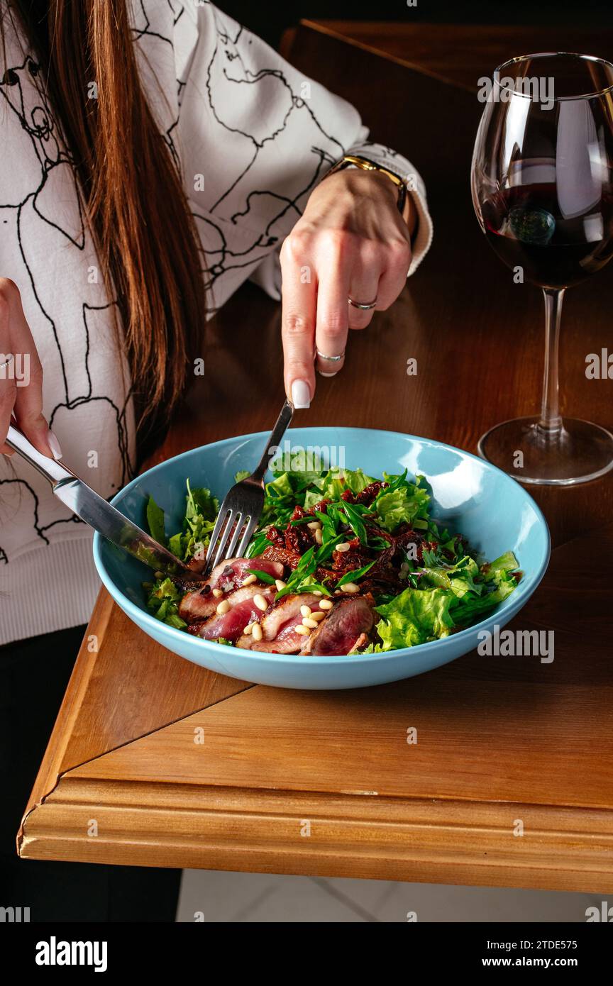 The girl has a salad with duck Stock Photo