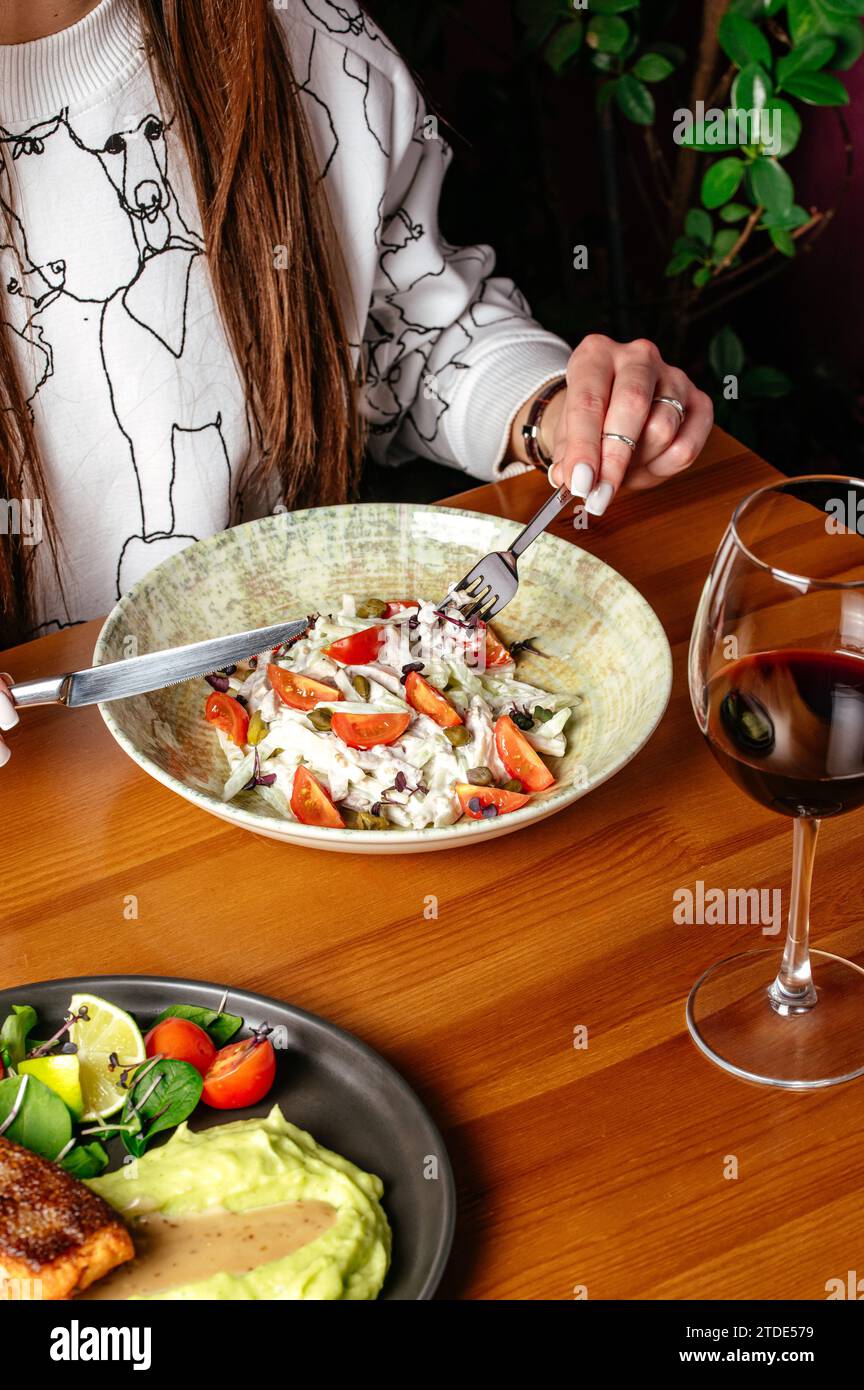 a girl eats a vegetable salad with meat Stock Photo