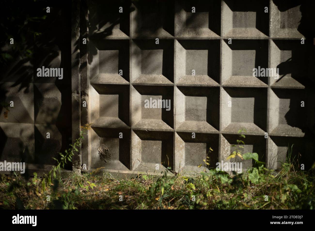 Concrete cage fence. Concrete fence in sunlight. Shadow on the wall