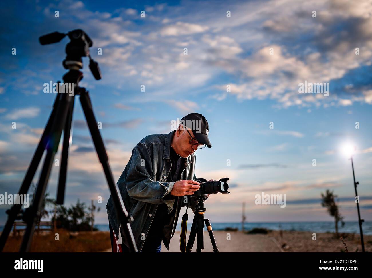 Man taking photographs at sunset. Stock Photo