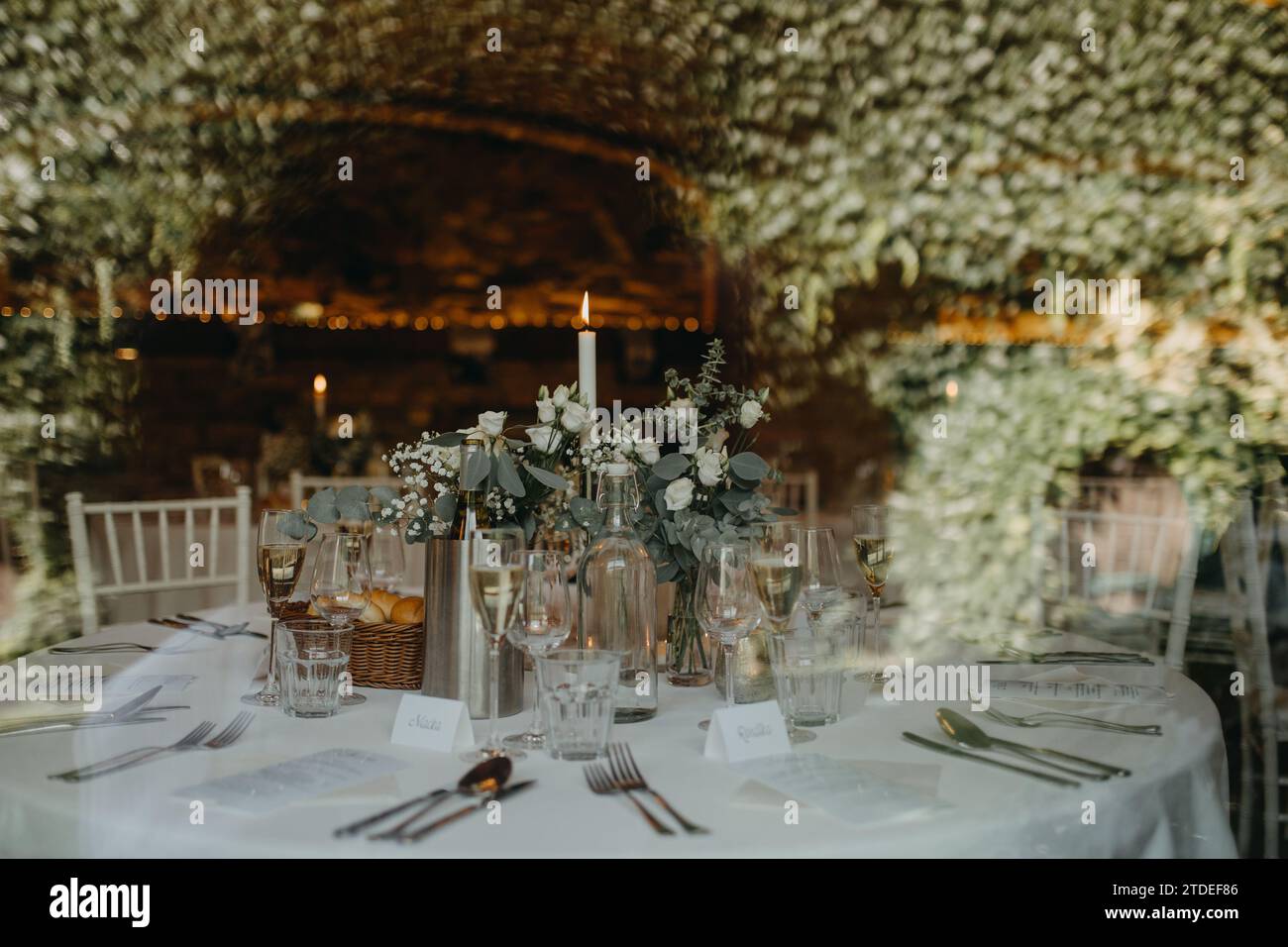 Elegant, romantic table setting for indoor wedding reception with fairy