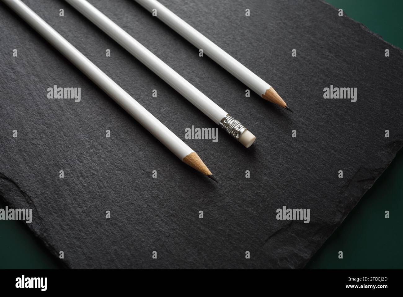 Three blank white pencils on stone board background. Stock Photo
