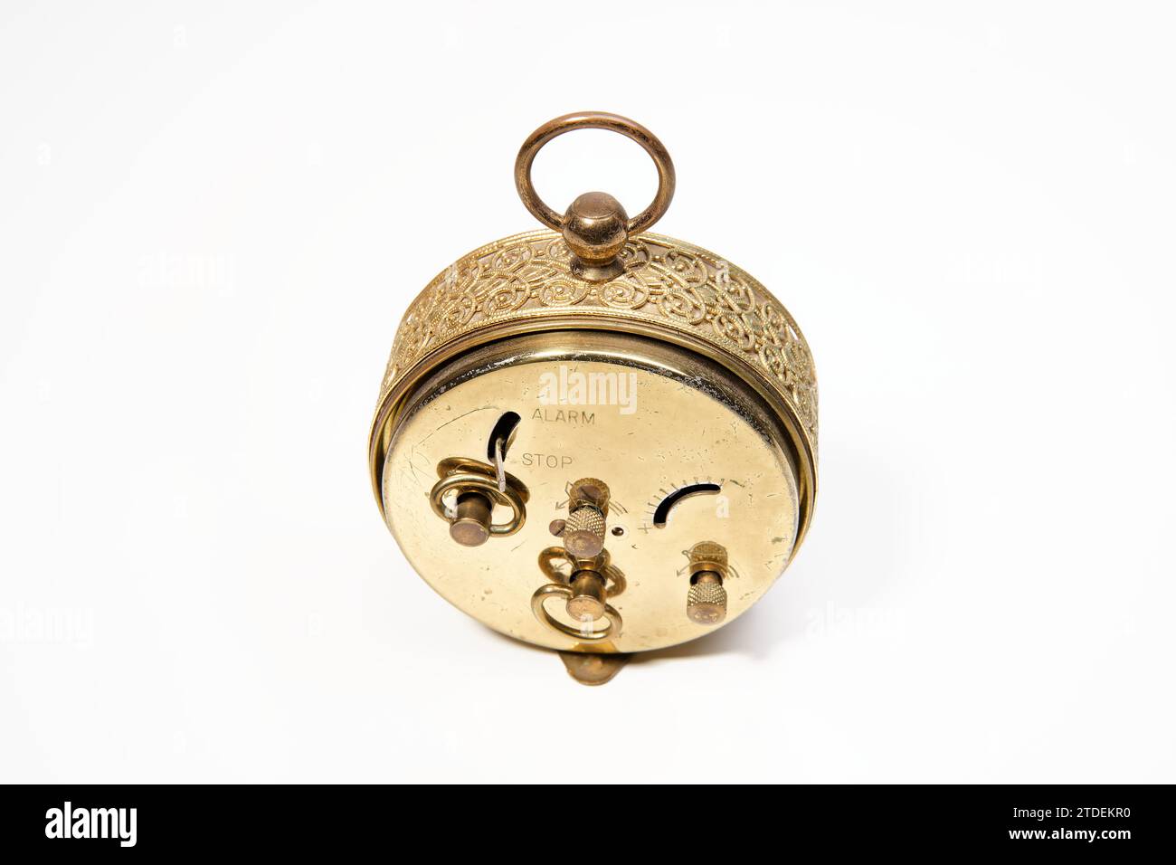 an old golden analog alarm clock with mechanical movement isolated on a