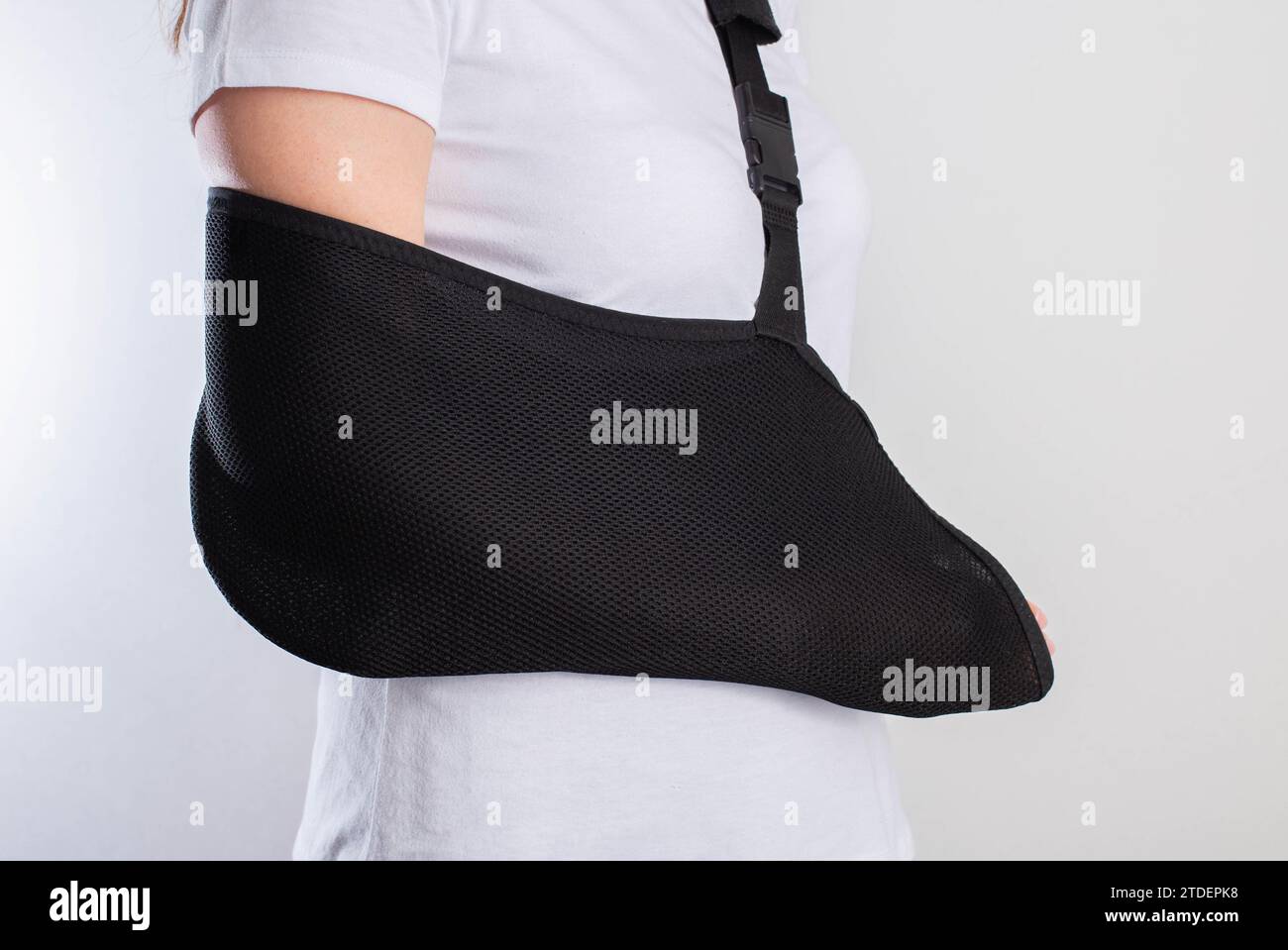 A girl's arm in a black support bandage after a broken arm and sprained shoulder joint. Rehabilitation after injury Stock Photo