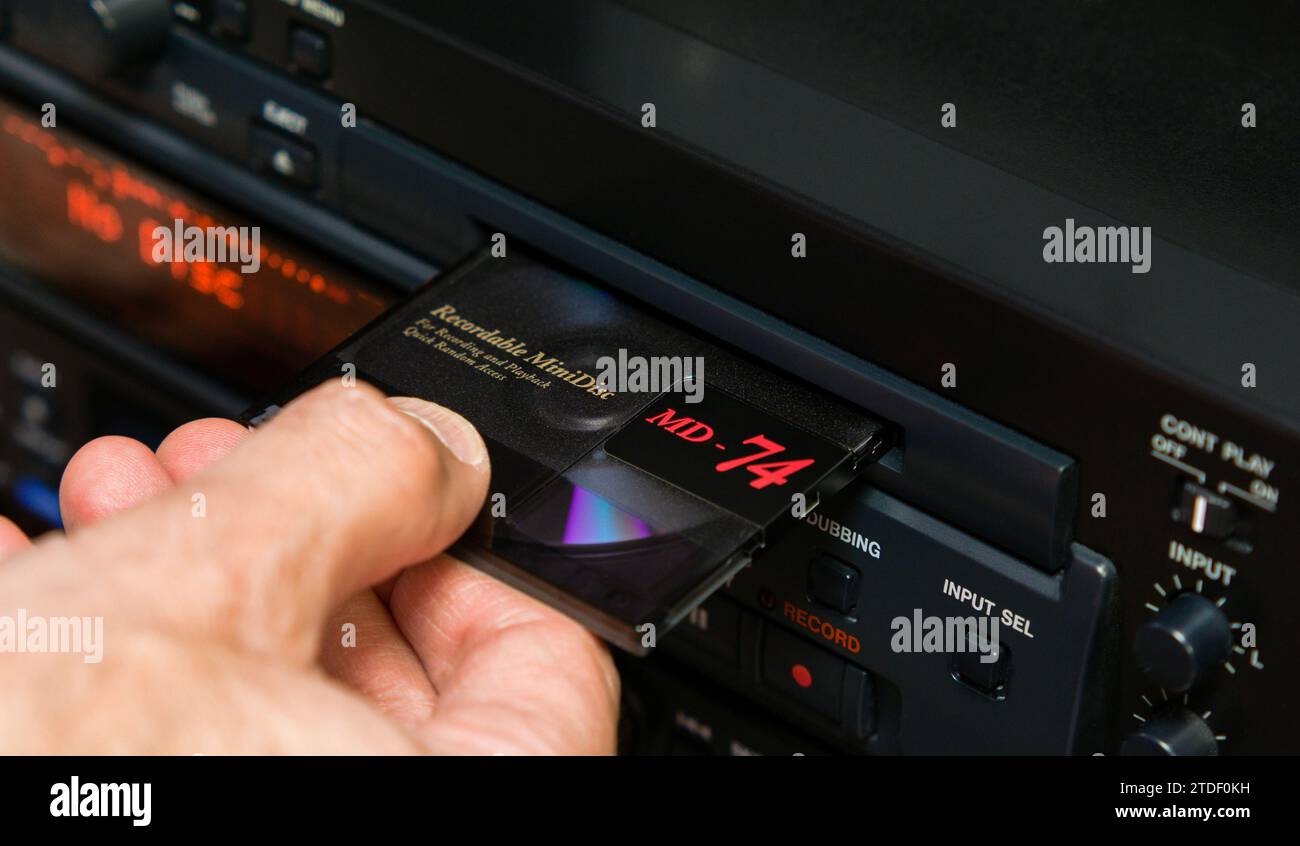 Man's hand removes a disc from the slot of a professional minidisc player Stock Photo