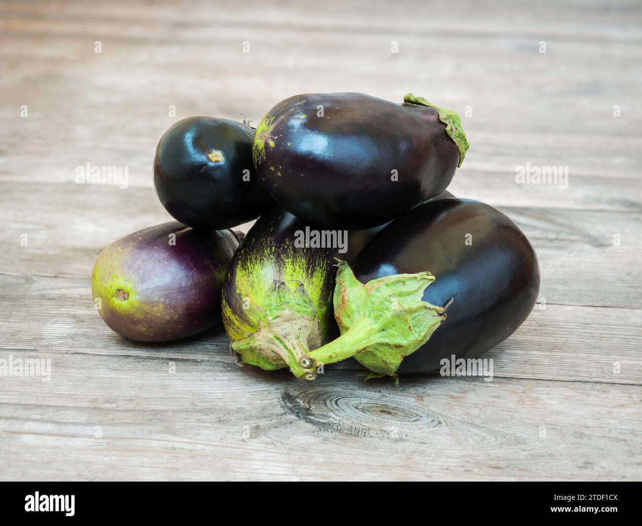 Fresh eggplants on an unpainted wooden rustic table Stock Photo