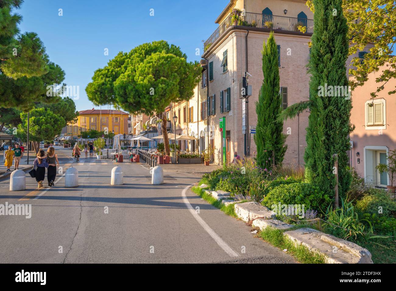 View of colourful buildings, cafe and cypress trees in Borgo San Giuliano, Rimini, Emilia-Romagna, Italy, Europe Stock Photo