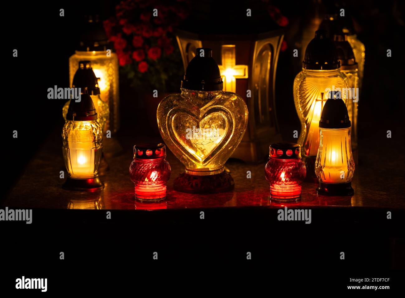 Night shot of the flames of glass cemetery candles standing on