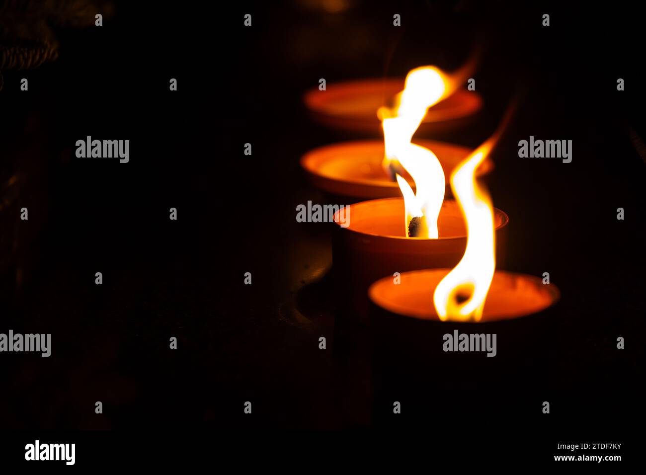 Night shot of the flames of glass cemetery candles standing on