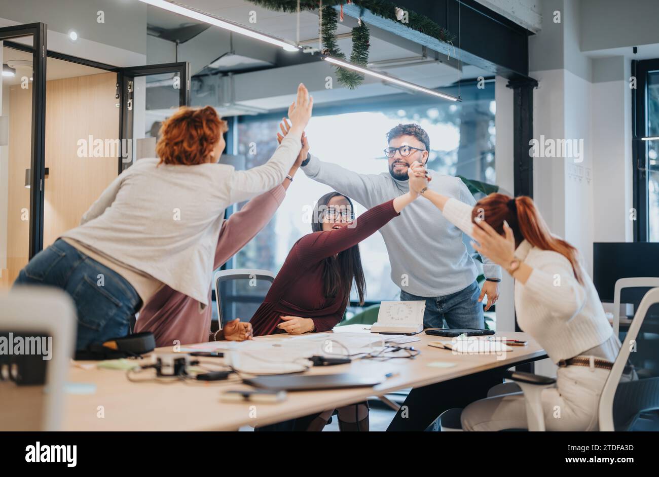 Multicultural team celebrates successful project with smiles and happiness. Stock Photo