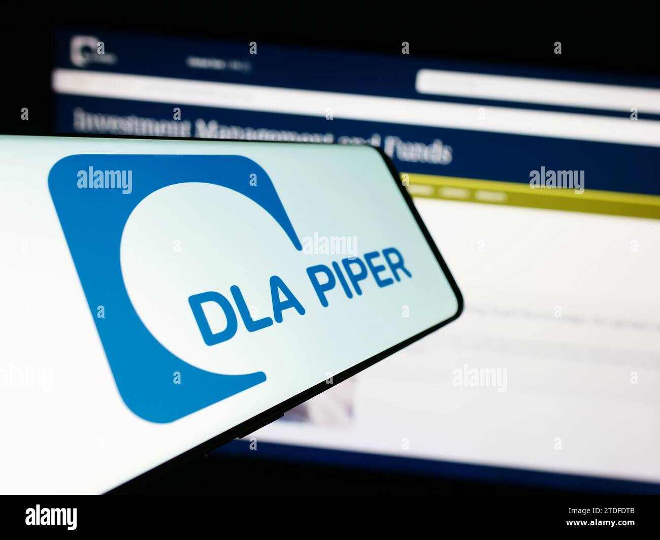 Cellphone with logo of law firm DLA Piper in front of business website. Focus on center of phone display. Stock Photo