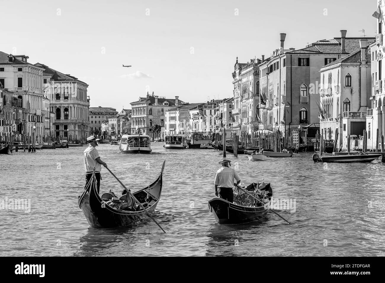 Two gondoliers cross the famous Grand Canal in Venice, Italy, in black and white Stock Photo