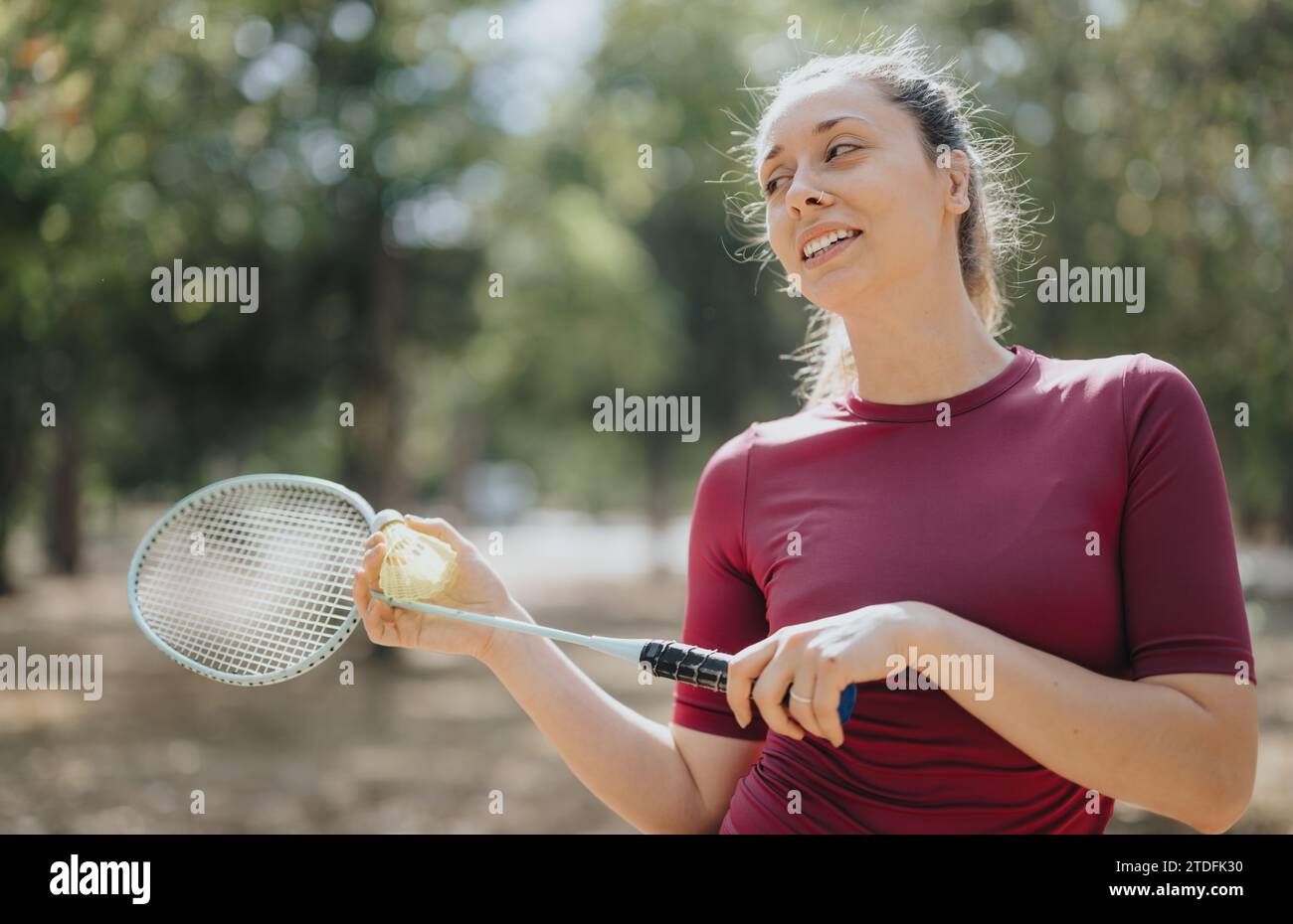 Photo Poses With Racket Attractive girl posing with racket after training in a park. Enjoying ...
