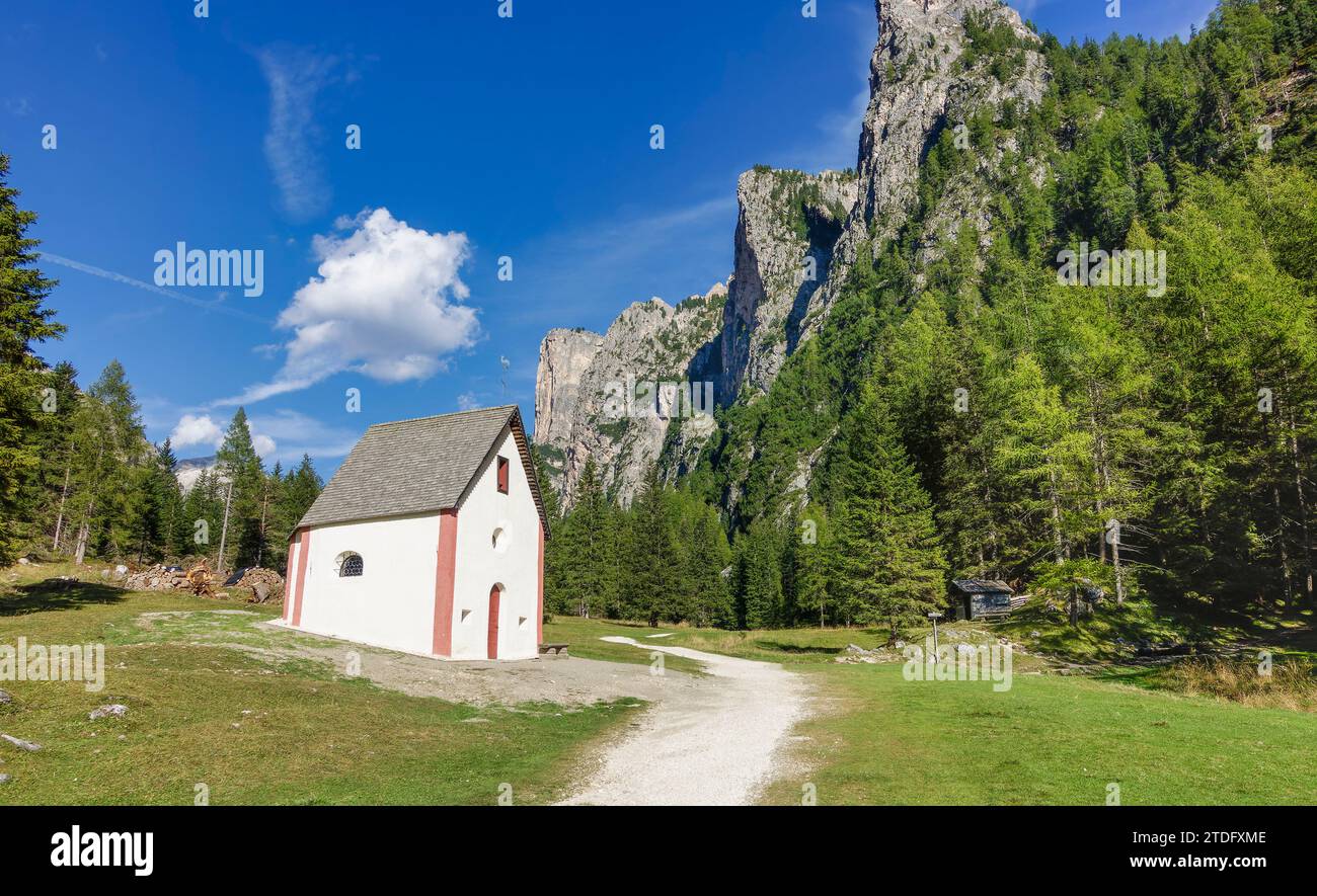 Small sylvester chapel in Vallunga valley Langental in Val Gardena. Green meadows and blue sky creating beautiful scenery. Stock Photo