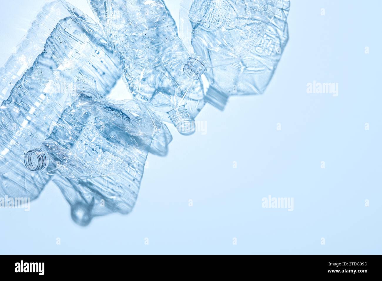 On a blue background, crushed plastic bottles are collected separately Stock Photo