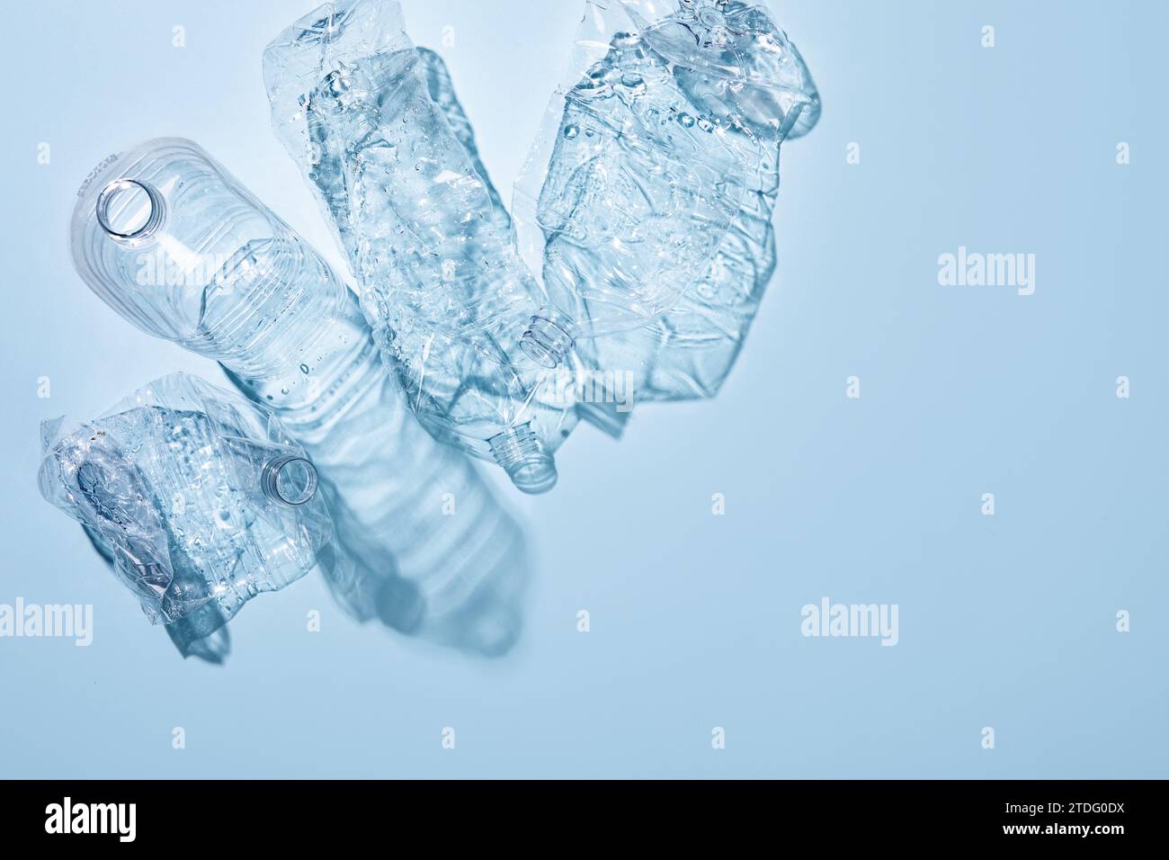 On a blue background, crushed plastic bottles are collected separately Stock Photo