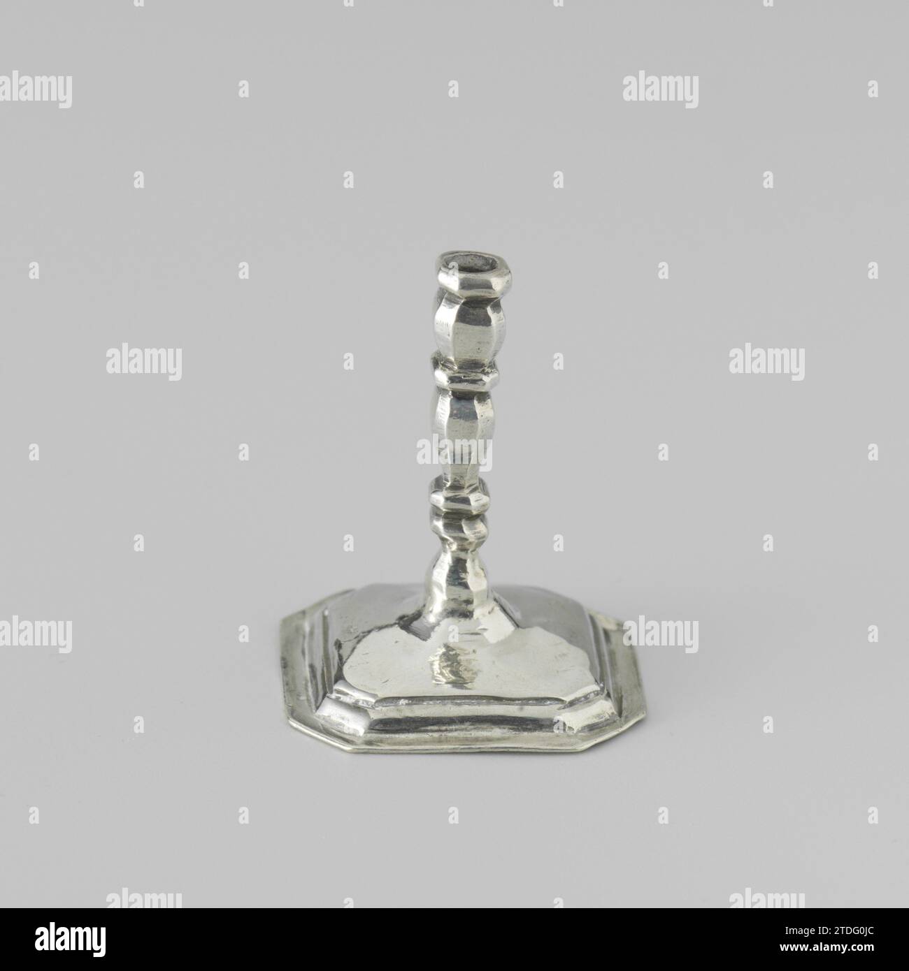 Candlestick, anonymous, c. 1704 - c. 1734 Candlestick on a square, curved foot with beveled corners. The trunk of the candlestick and the edge of the foot are profiled. The candlestick is marked: stk. = Amsterdam, Mt. = Citroen 1975, no. 970 and an ax. The candlestick is the same as the candlestick with invnr. BK-NM-4329. Amsterdam silver (metal) Candlestick on a square, curved foot with beveled corners. The trunk of the candlestick and the edge of the foot are profiled. The candlestick is marked: stk. = Amsterdam, Mt. = Citroen 1975, no. 970 and an ax. The candlestick is the same as the candl Stock Photo