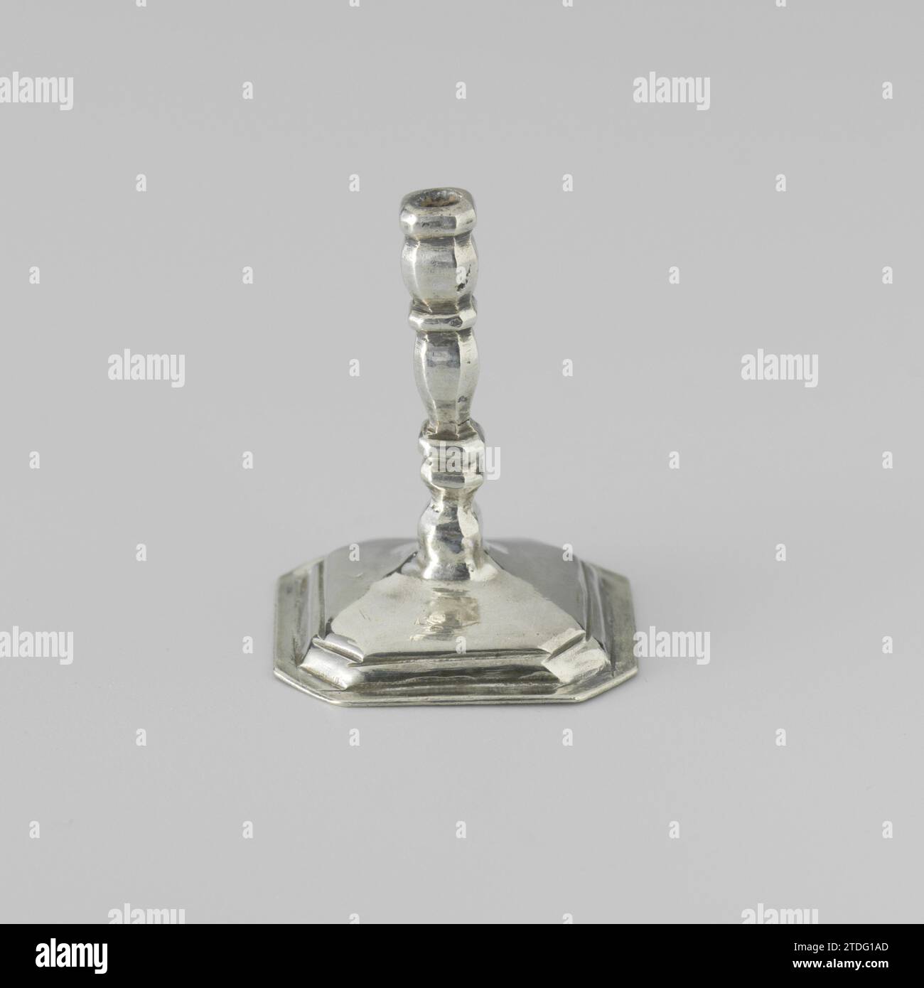 Candlestick, anonymous, c. 1704 - c. 1734 Candlestick on a square, curved foot with beveled corners. The trunk of the candlestick and the edge of the foot are profiled. The candlestick is marked: stk. = Amsterdam, Mt. = Citroen 1975, no. 970 and an ax. The candlestick is the same as the candlestick with invnr. BK-NM-4336-J. Amsterdam silver (metal) Candlestick on a square, curved foot with beveled corners. The trunk of the candlestick and the edge of the foot are profiled. The candlestick is marked: stk. = Amsterdam, Mt. = Citroen 1975, no. 970 and an ax. The candlestick is the same as the can Stock Photo