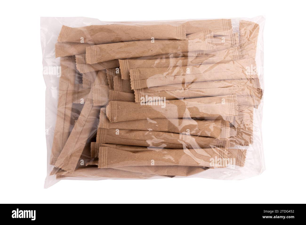heap of sugar sticks in transparent plastic bag, sugar in paper kraft packaging, mock up for design isolated on white background with clipping path Stock Photo